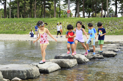 くらかけ清流の郷の飛び石を子どもたちが歩いている写真