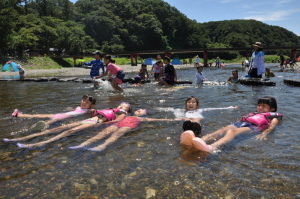服を着たまま川で浮かぶ女の子達の写真