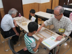 将棋を教わる子ども2人の様子