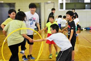 フラフープを使ったゲームに取り組む児童達